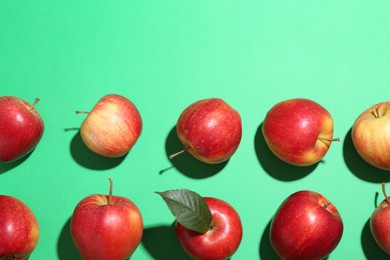 Photo of Red apples on green background, flat lay