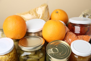 Photo of Different food products for donation on beige background, closeup