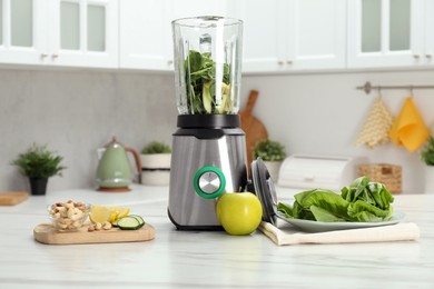 Photo of Modern blender with ingredients for smoothie on white marble table in kitchen