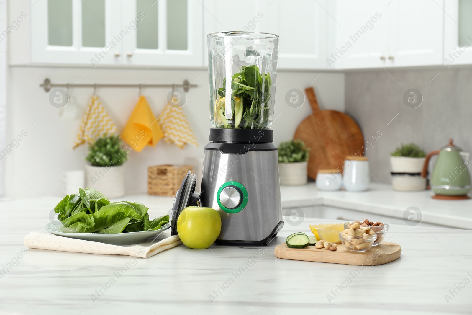 Photo of Modern blender with ingredients for smoothie on white marble table in kitchen