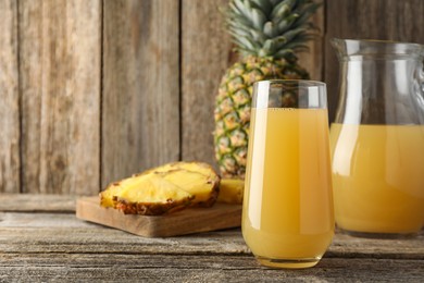 Photo of Tasty pineapple juice and fresh fruit on wooden table, closeup. Space for text