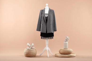 Photo of Mannequin with stylish dress, jacket and shoes on beige background