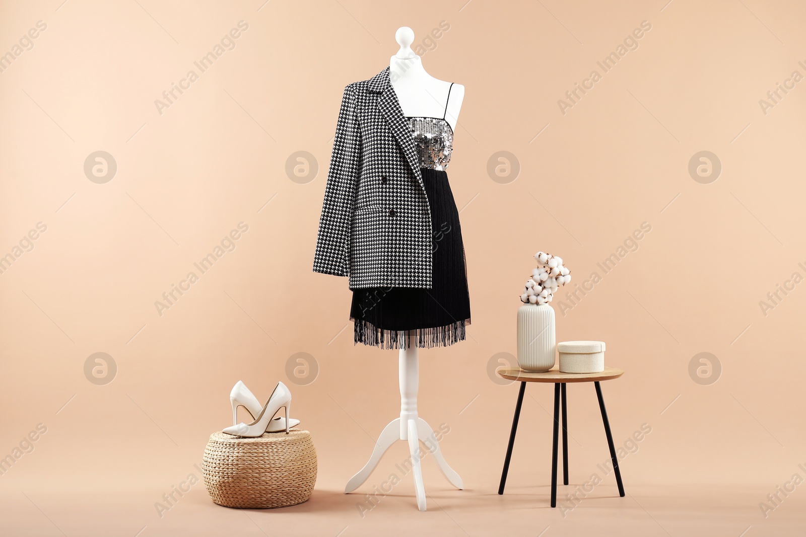 Photo of Mannequin with stylish dress, jacket and shoes on beige background