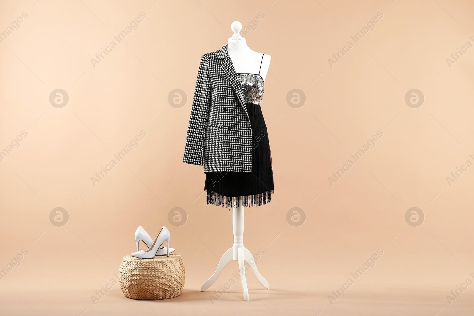 Photo of Mannequin with stylish dress, jacket and shoes on beige background