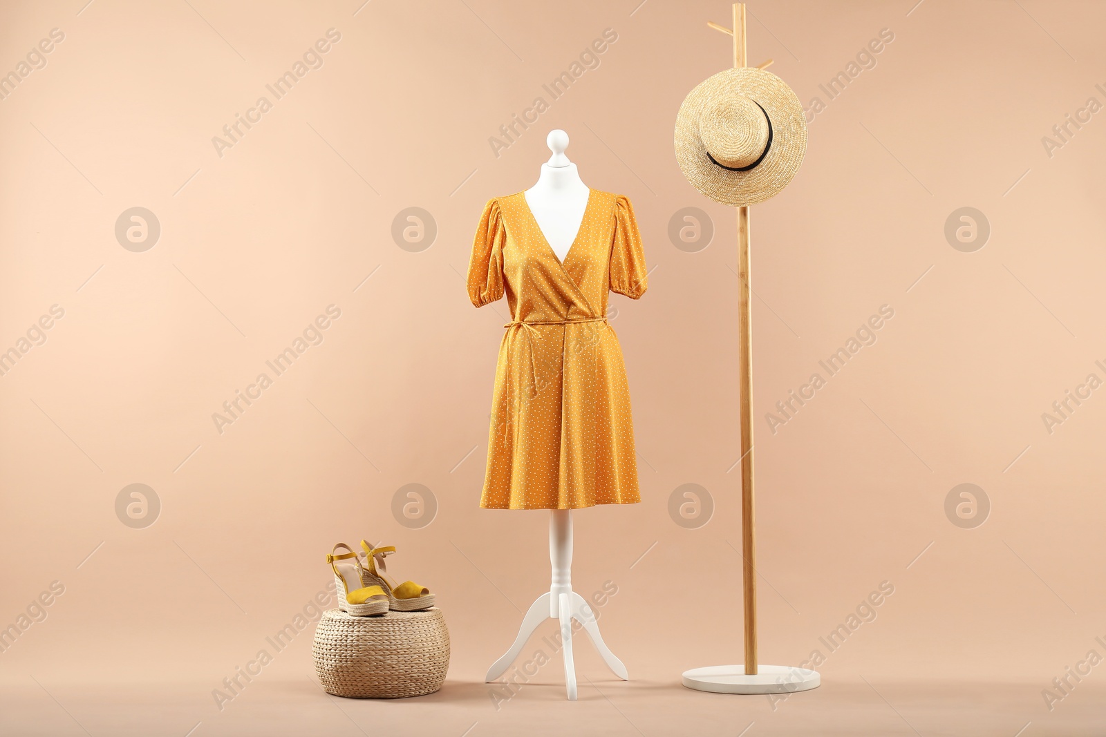 Photo of Mannequin with stylish dress, shoes and hat on beige background