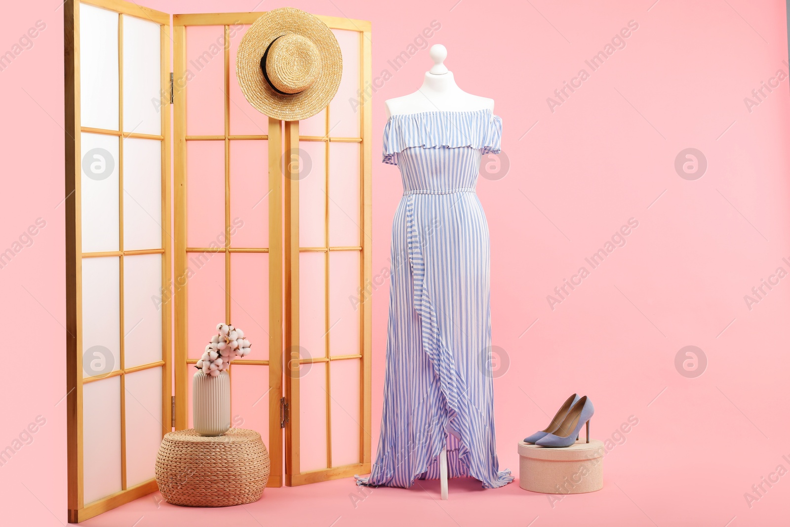 Photo of Mannequin with stylish dress, folding screen, hat and shoes on pink background