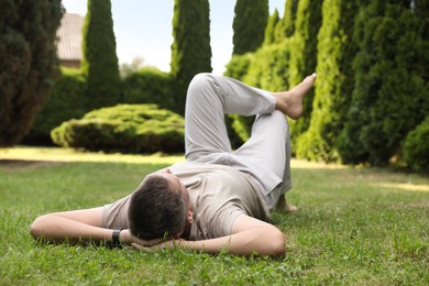 Man resting on green lawn in park