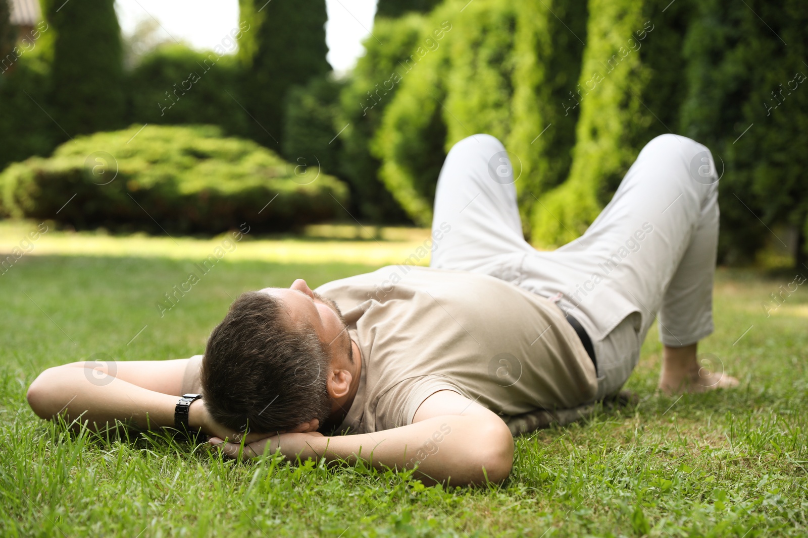 Photo of Man resting on green lawn in park