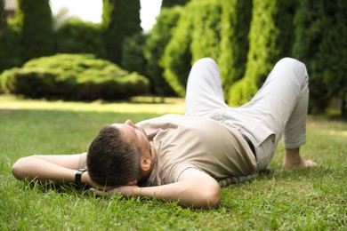 Man resting on green lawn in park