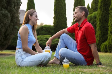 Couple spending time together on green lawn in park