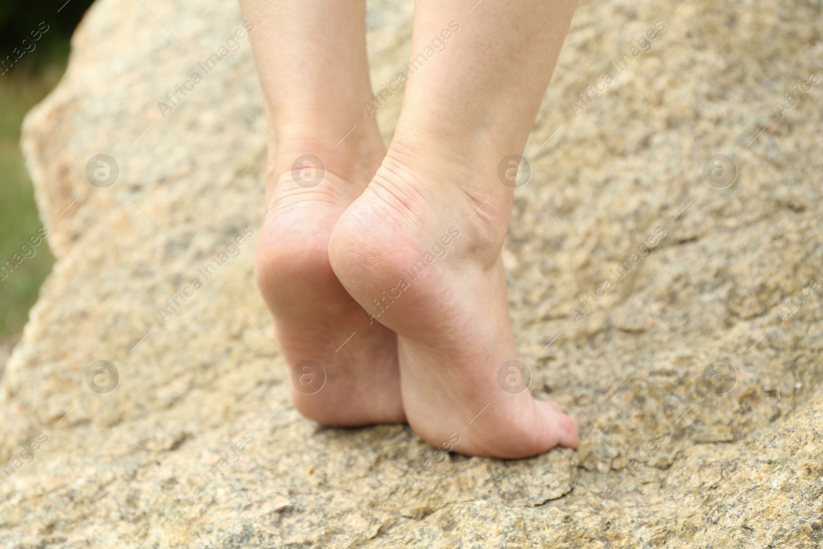 Photo of Woman standing barefoot on rock outdoors, closeup