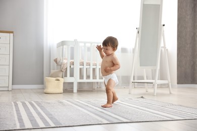 Photo of Cute little child in diaper at home