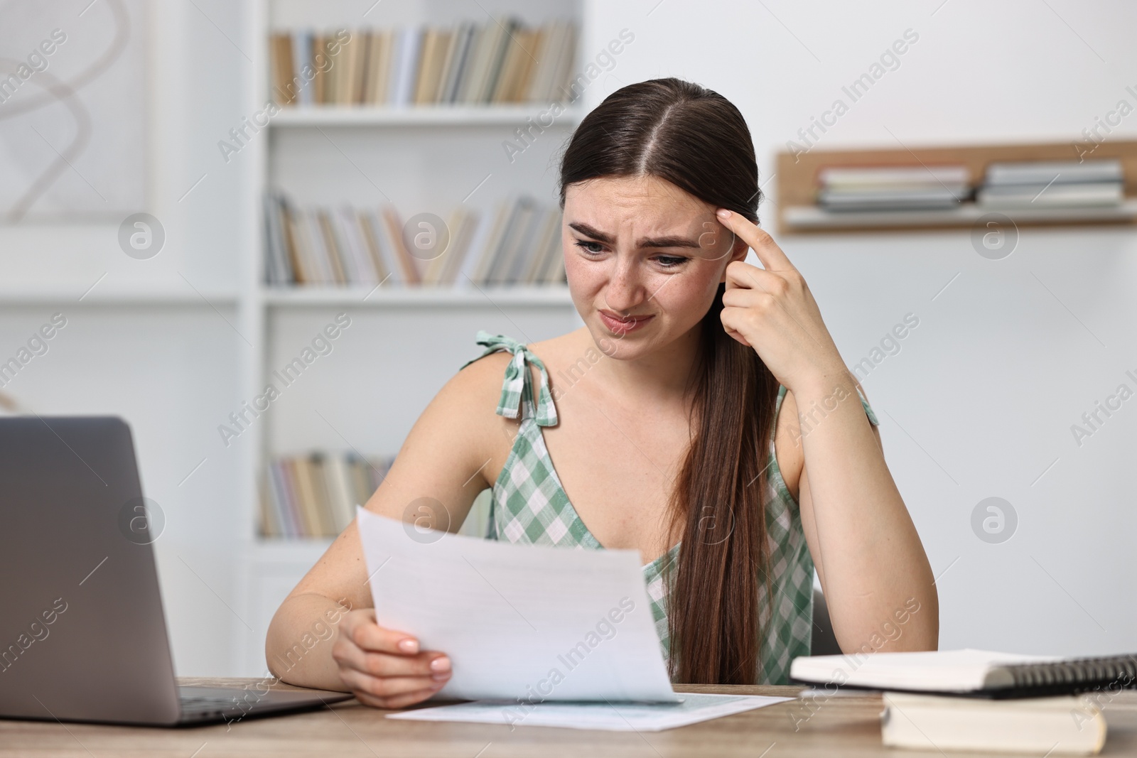 Photo of Tired student having stress before exam at table indoors