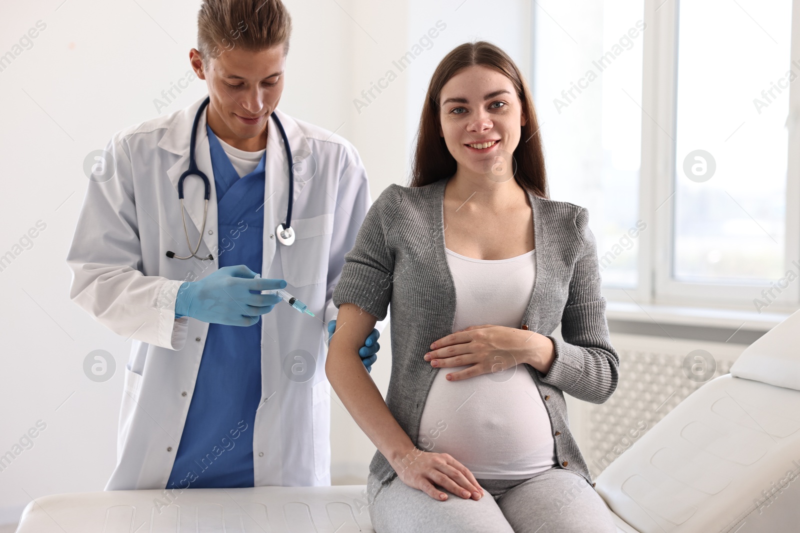 Photo of Doctor giving injection to pregnant woman at hospital