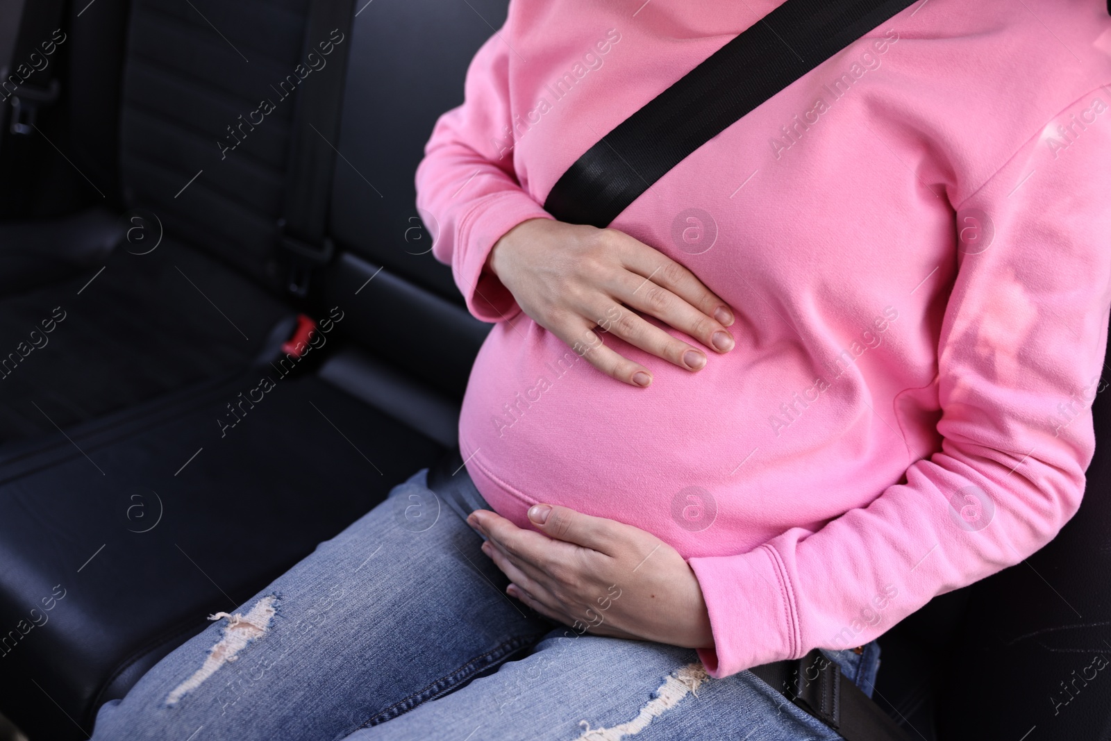 Photo of Pregnant woman with safety belt in car, closeup