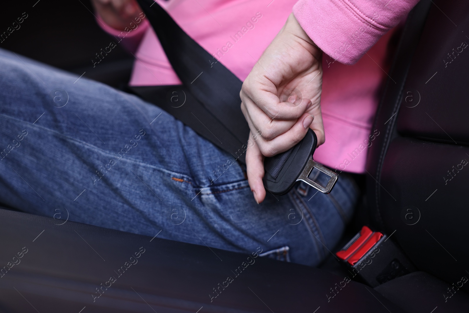 Photo of Pregnant woman fastening safety belt in car, closeup