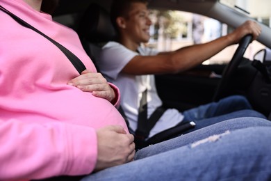 Photo of Pregnant woman travelling with her husband by car, closeup