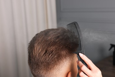 Hair cutting. Professional hairdresser working with client in barbershop, closeup