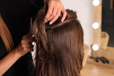 Hair cutting. Professional hairdresser working with client in salon, closeup