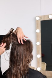 Hair cutting. Professional hairdresser working with client in salon, closeup