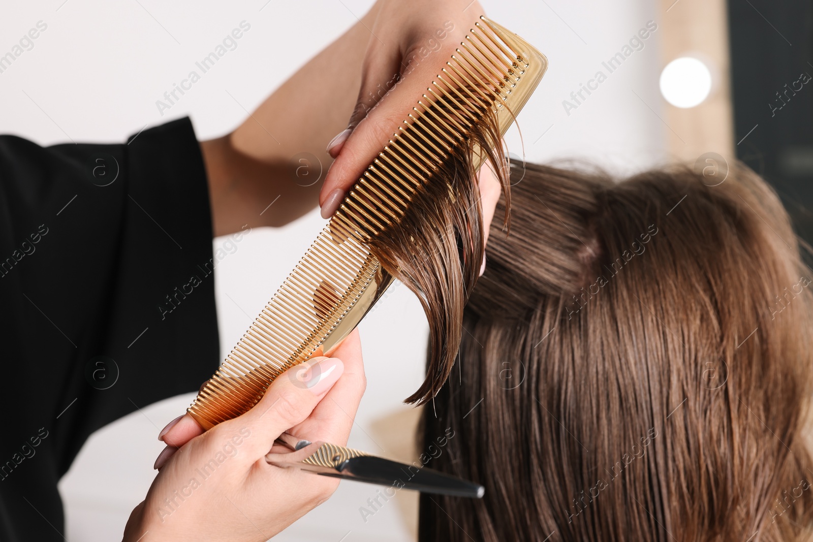 Photo of Hair cutting. Professional hairdresser working with client in salon, closeup