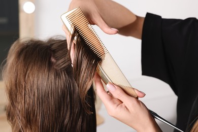 Photo of Hair cutting. Professional hairdresser working with client in salon, closeup