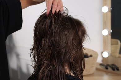 Hair cutting. Professional hairdresser working with client in salon, closeup