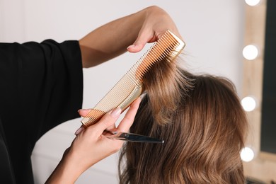 Hair cutting. Professional hairdresser working with client in salon, closeup