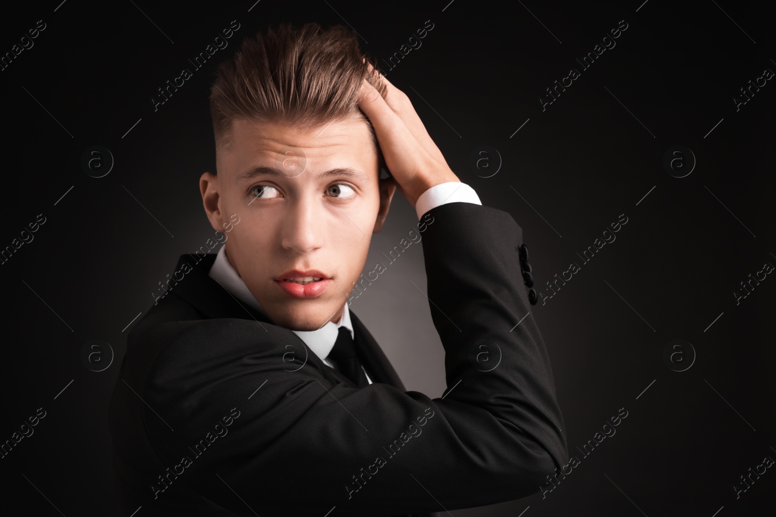 Photo of Confident young man with stylish haircut on black background