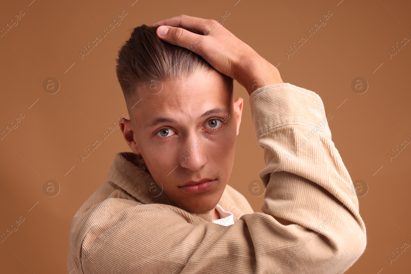 Photo of Young man with stylish haircut on brown background