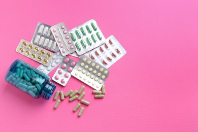 Pharmacist concept. Flat lay composition with many different pills on pink background, space for text