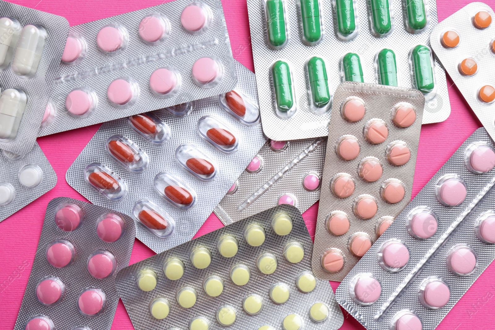 Photo of Pharmacist concept. Flat lay composition with many different pills on pink background