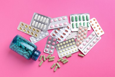 Pharmacist concept. Flat lay composition with many different pills on pink background