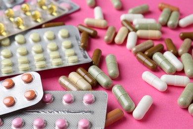 Photo of Pharmacist concept. Many different pills on pink background, closeup