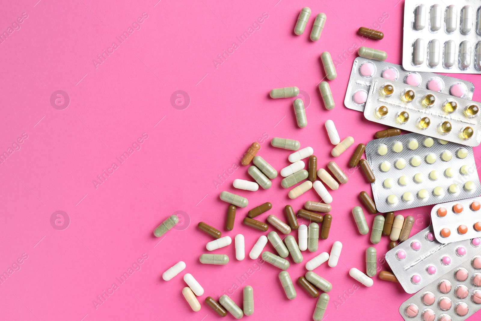 Photo of Pharmacist concept. Flat lay composition with many different pills on pink background, space for text