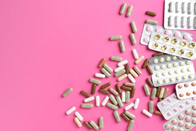 Photo of Pharmacist concept. Flat lay composition with many different pills on pink background, space for text