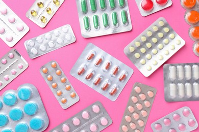 Photo of Pharmacist concept. Flat lay composition with many different pills on pink background