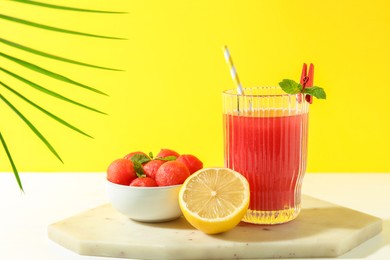 Photo of Tasty watermelon drink in glass and fresh fruits on white table