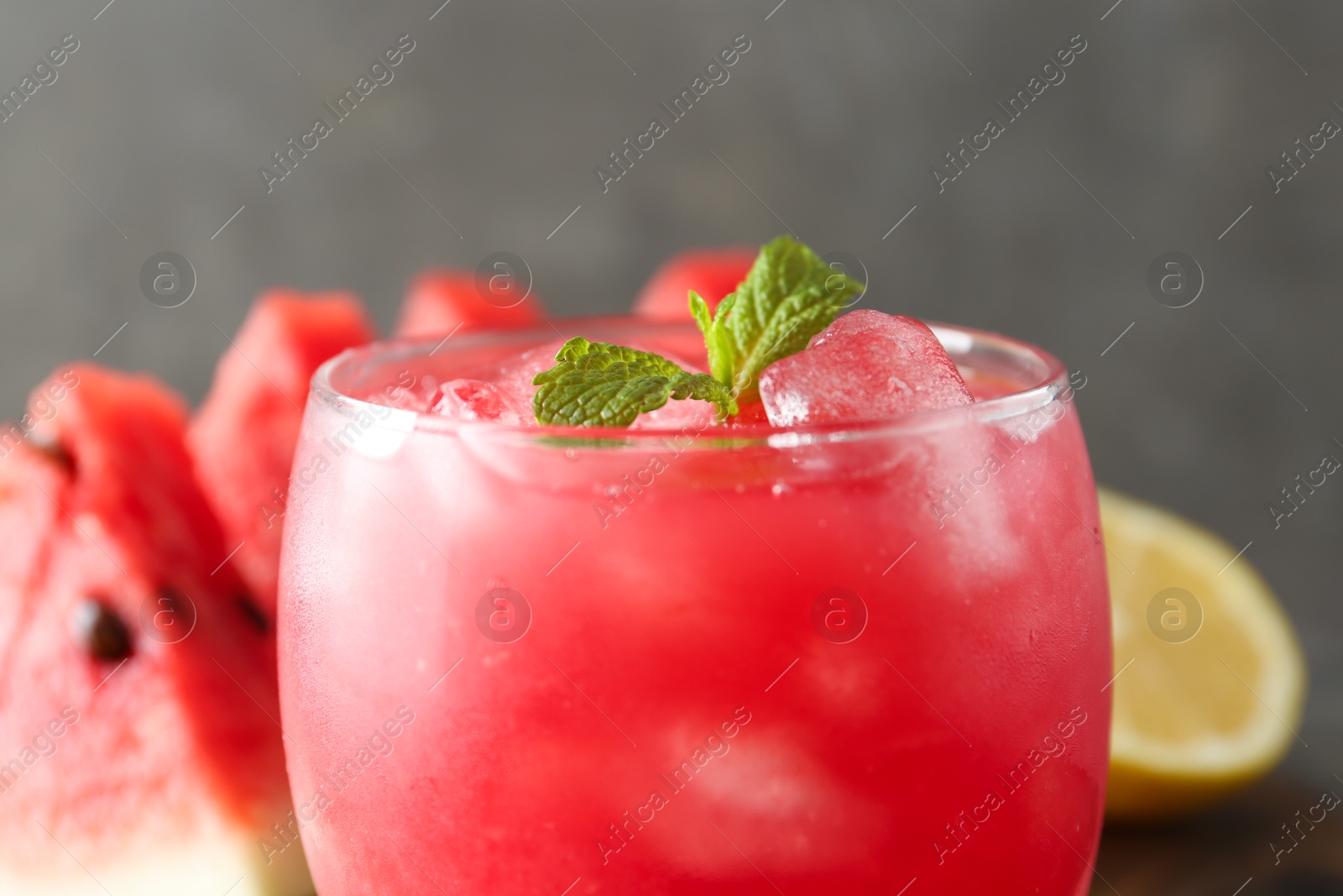 Photo of Tasty watermelon drink in glass on blurred background, closeup