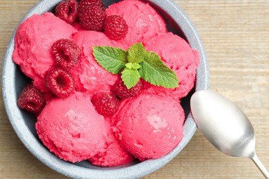 Delicious raspberry sorbet, fresh berries and mint in bowl served on wooden table, top view