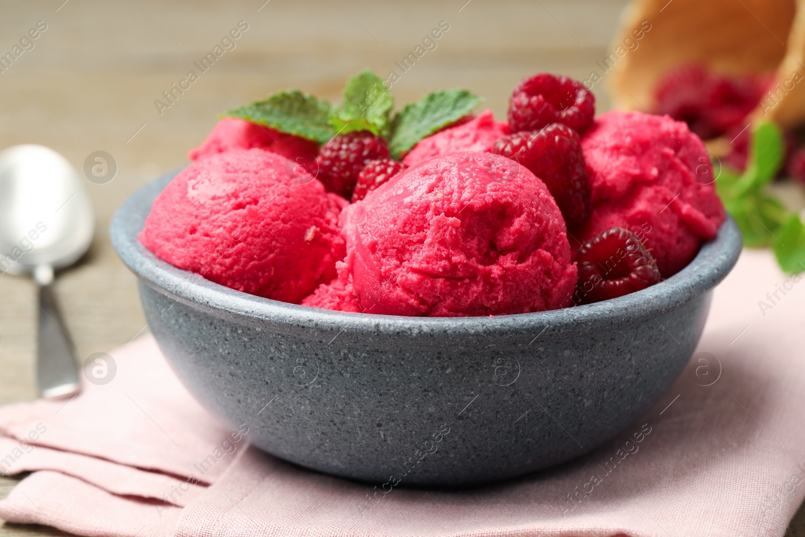 Photo of Delicious raspberry sorbet, fresh berries and mint in bowl on light table, closeup