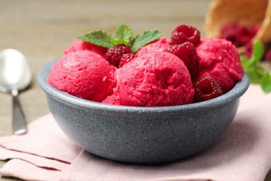 Photo of Delicious raspberry sorbet, fresh berries and mint in bowl on light table, closeup