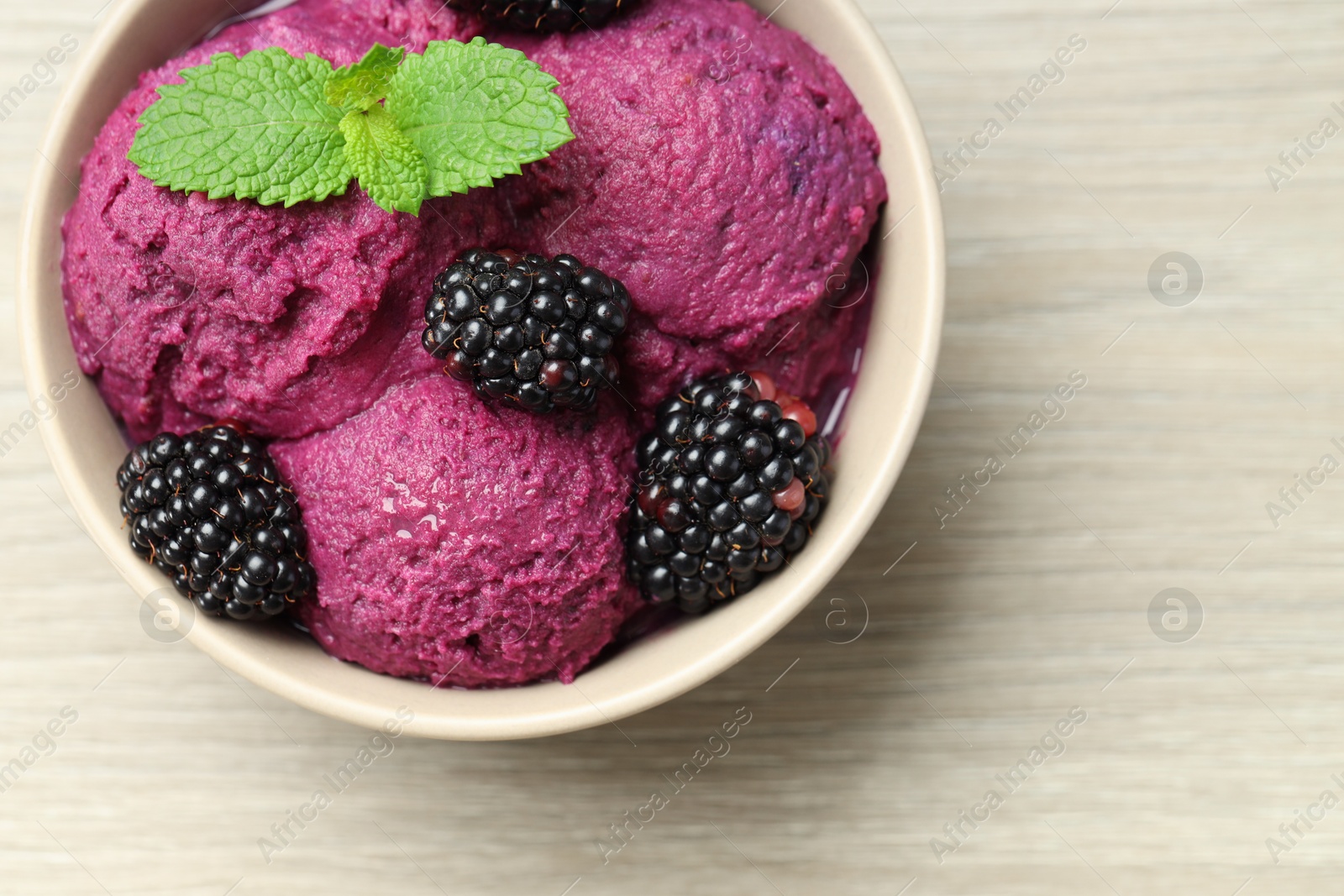 Photo of Delicious blackberry sorbet, fresh berries and mint in bowl on wooden table, top view