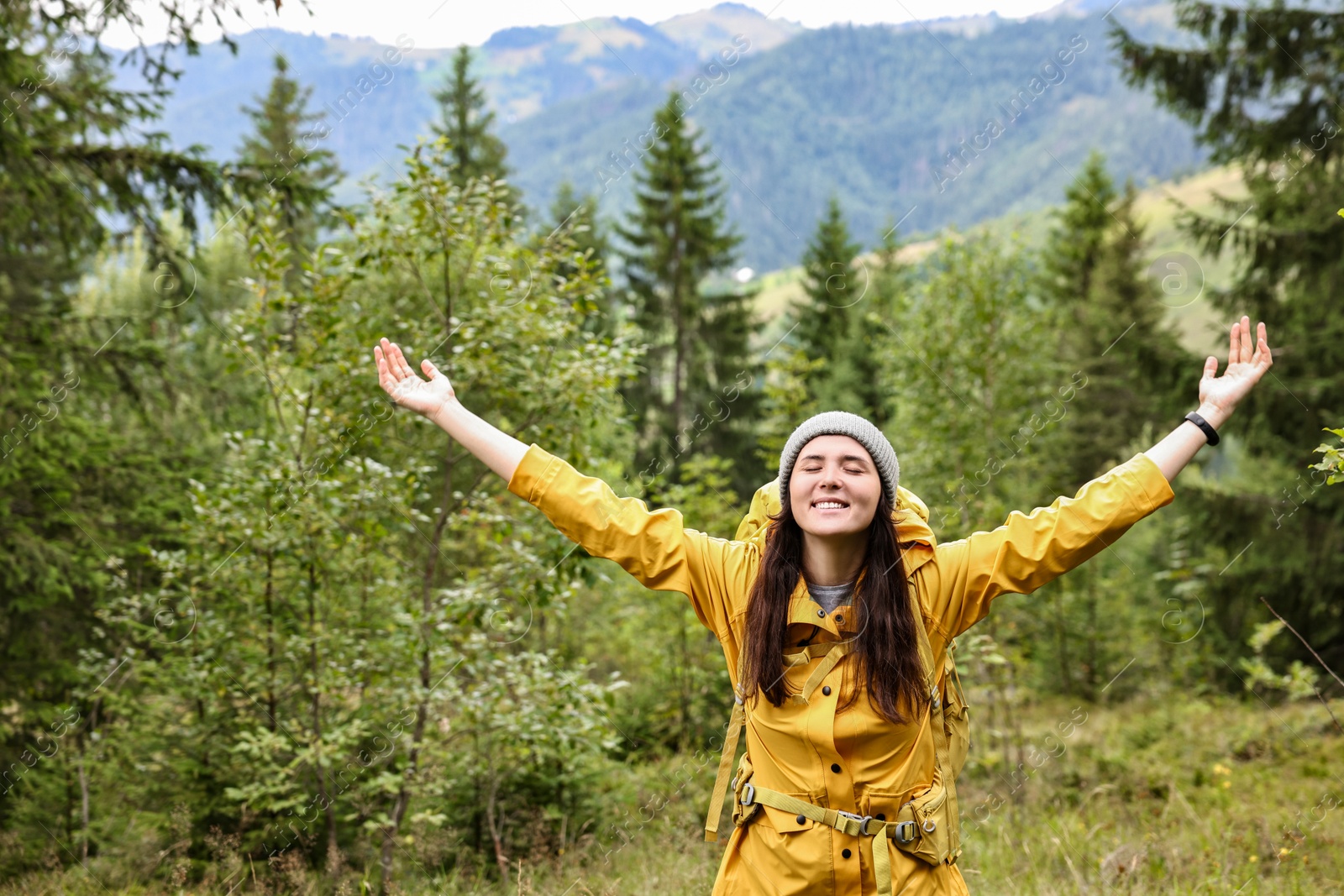 Photo of Young hiker with backpack in forest near mountains. Active tourism