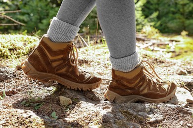 Young hiker in trekking shoes walking outdoors, closeup