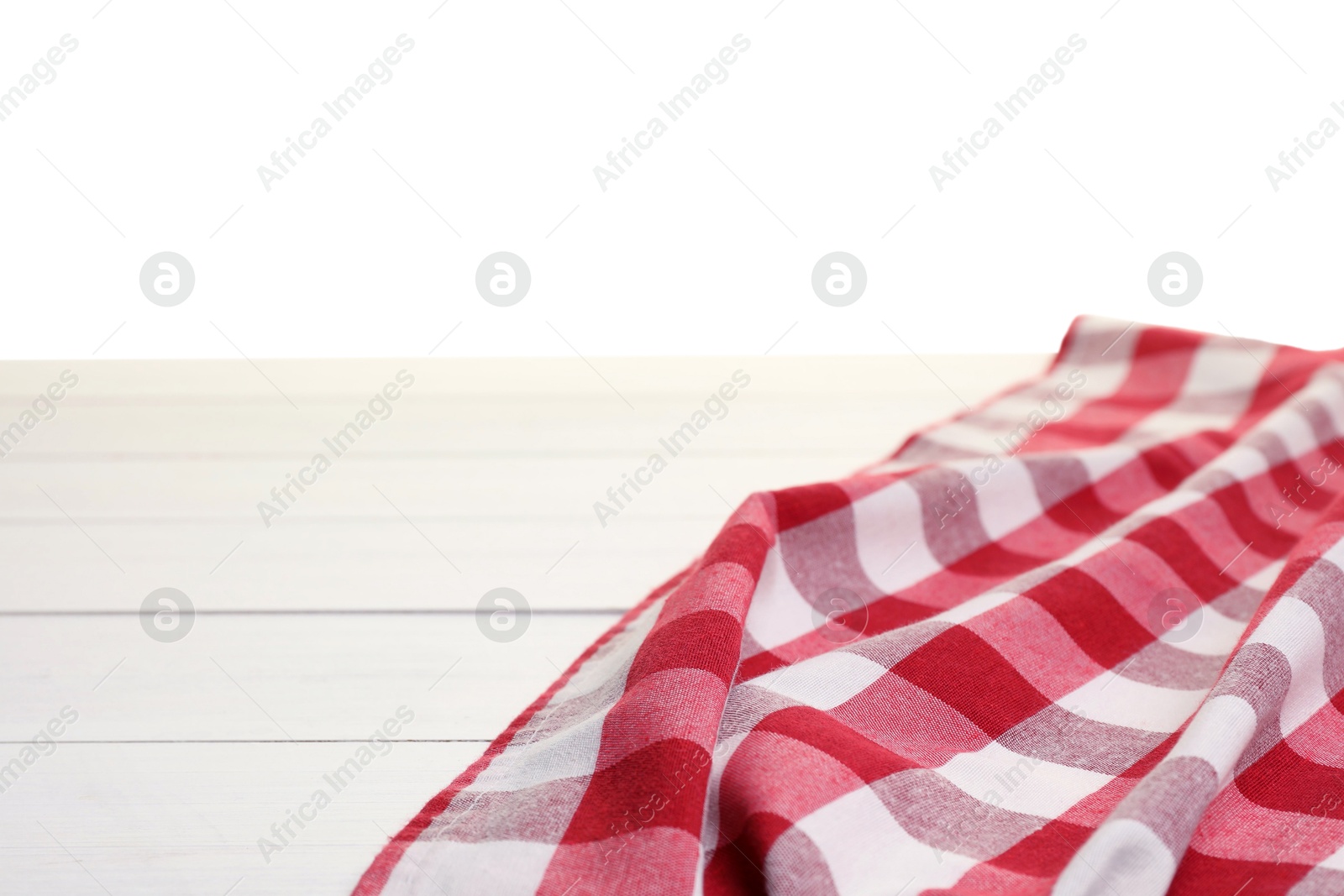 Photo of Crumpled tablecloth with checkered pattern on wooden table against white background