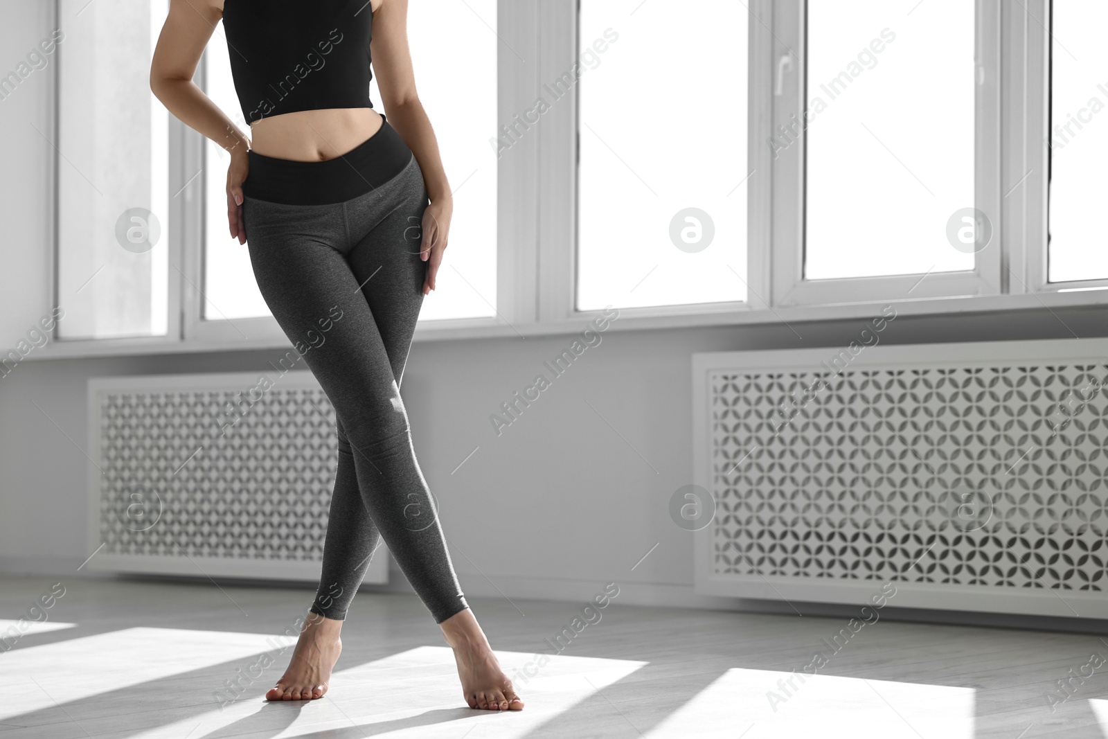 Photo of Woman wearing sports leggings indoors, closeup. Space for text