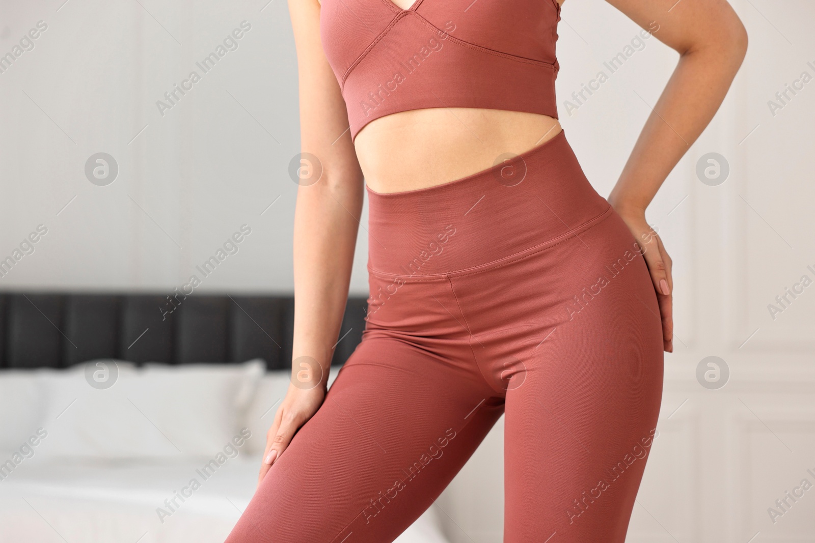 Photo of Woman wearing sports leggings and bra indoors, closeup