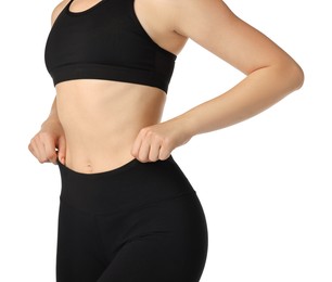 Photo of Woman wearing black sports leggings and bra on white background, closeup