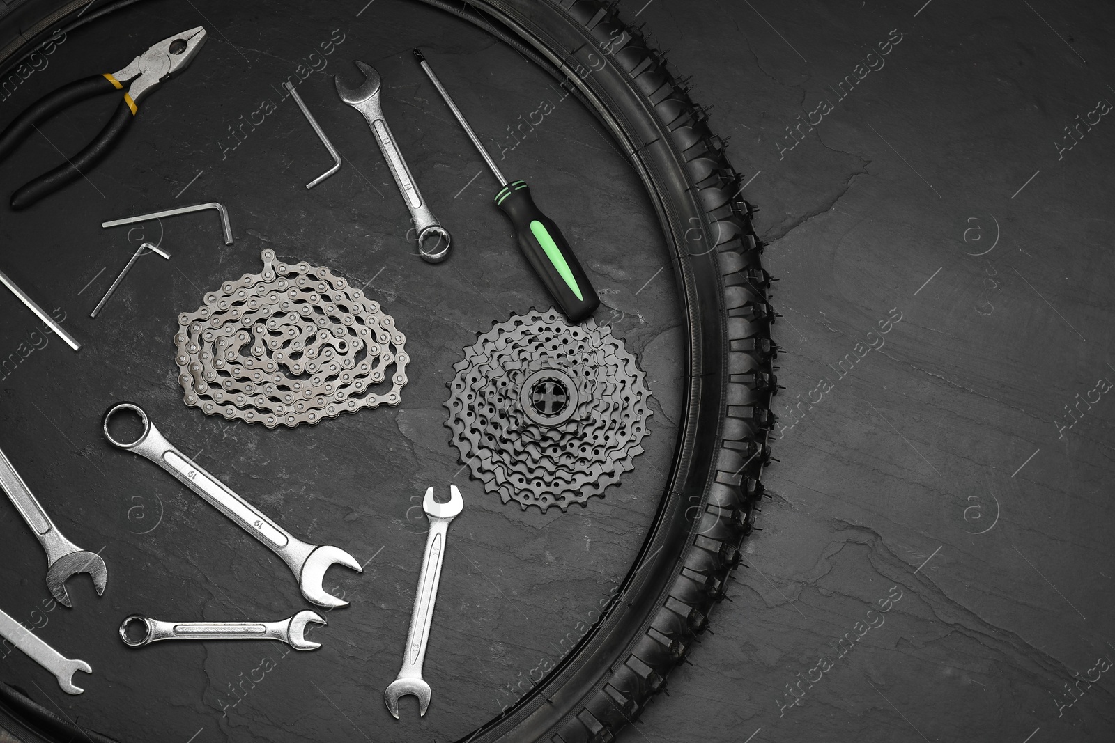 Photo of Parts of bicycle and tools on black table, flat lay. Space for text